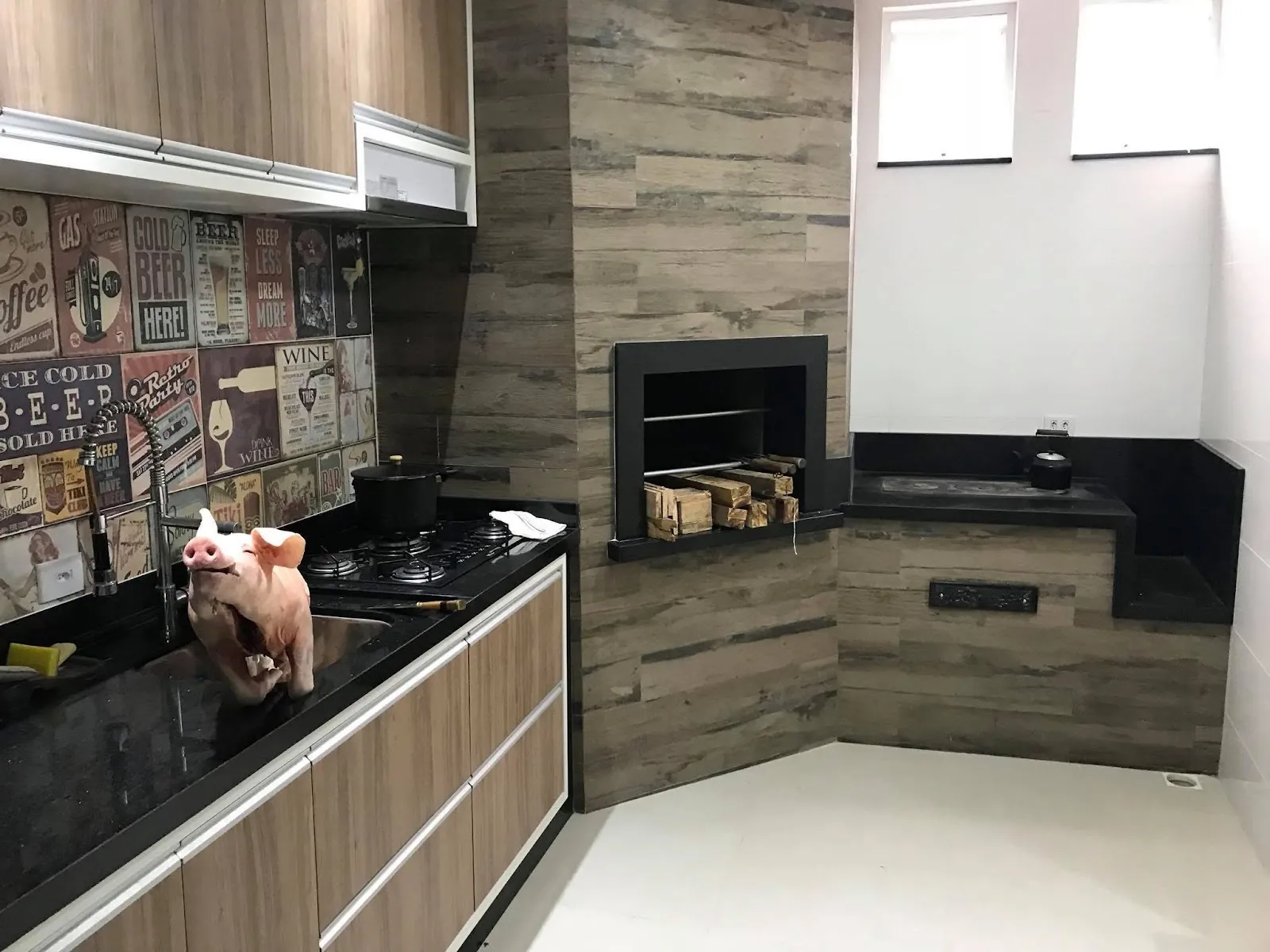 Área gourmet com bancada em granito preto e churrasqueira
