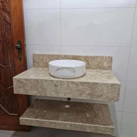 Bancada de banheiro em mármore bege com cuba de apoio e prateleira